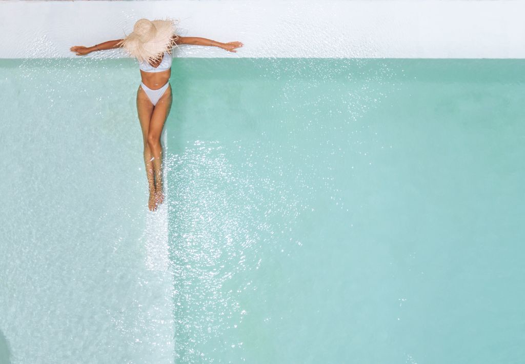 this is an image of a sexy woman in a modern-style pool relaxing in a tropical modern architecture environment